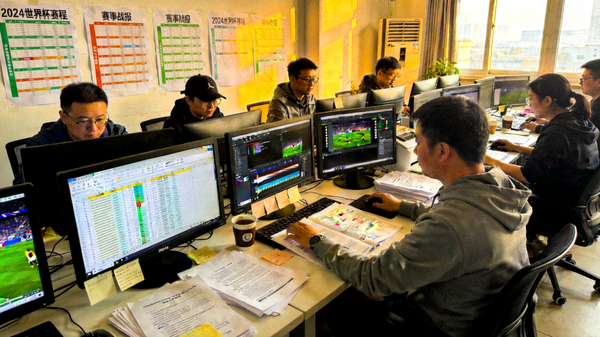 体育新闻编辑室中赛事资讯整理与稿件编排的工作场景